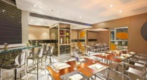 a restaurant with tables and chairs and a bar at Elysion Place Hotel Causeway Bay in Hong Kong