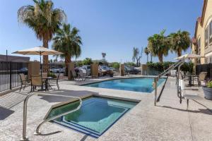 une piscine avec chaises et parasols dans un complexe hôtelier dans l'établissement Best Western Tolleson Hotel, à Phoenix