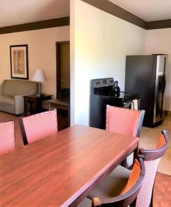 Il comprend une cuisine avec une table et des chaises en bois ainsi qu'une cuisine équipée d'un réfrigérateur. dans l'établissement Best Western Tolleson Hotel, à Phoenix