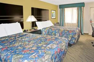 une chambre d'hôtel avec deux lits et une lampe dans l'établissement Howard Johnson by Wyndham Houston Heights/Downtown, à Houston