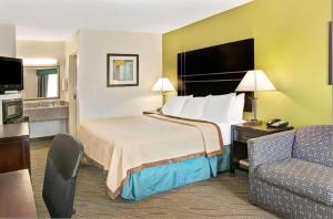 une chambre d'hôtel avec un lit et un canapé dans l'établissement Howard Johnson by Wyndham Houston Heights/Downtown, à Houston