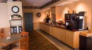 a restaurant with a bar with a counter and a kitchen at Country Inn & Suites by Radisson, Dundee, MI in Dundee