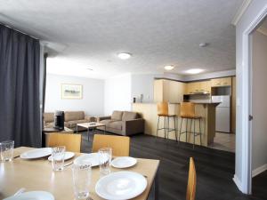 カラウンドラにあるCaloundra Central Apartment Hotel Officialのダイニングテーブルとリビングルームのある部屋