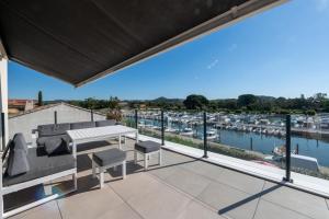 a balcony with a view of a marina at SUPERBE VILLA VUE MER JUSQU'A 14 COUCHAGES La LONDE LES MAURES Entre HYERES et Le LAVANDOU 4 Etoiles PISCINE CHAUFFEE in La Londe-les-Maures