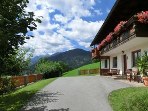 a driveway leading to a house with mountains in the background at Ferienhaus Schwab in Aich