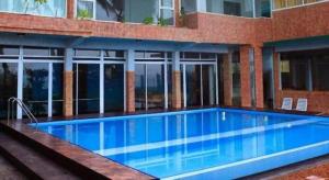 a large swimming pool in front of a building at OYO 246 Roy Villa Beach Hotel in Paiyagala North