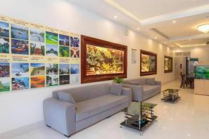 a living room with two couches and a tv at Luxury Airport Hotel & Spa in Phu Lo Dong