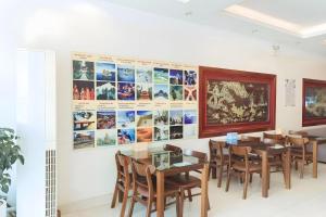 a dining room with tables and chairs and posters on the wall at Luxury Airport Hotel & Spa in Phu Lo Dong