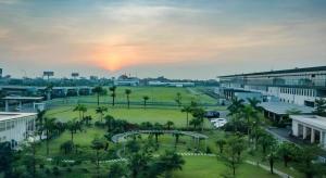 a view of a park with palm trees and buildings at Luxury Airport Hotel & Spa in Phu Lo Dong