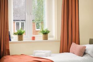 a bedroom with two potted plants in a window at 3Bedroom 5Bed 2Bath Ensuite Prv-Parkin x2 in Amersham