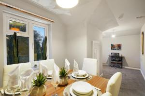 a dining room with a table and white chairs at King Size beds, CCTV parking , Discounts in Shinfield
