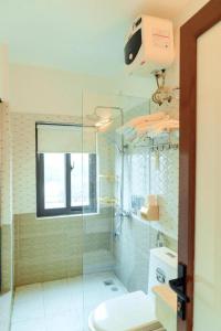 a bathroom with a glass shower and a toilet at Luxury Airport Hotel & Spa in Phu Lo Dong
