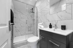 a bathroom with a shower and a toilet and a sink at 2 King or 4 Single Beds Workspace Walk to Bedford Station Parking Wi-Fi in Bedford