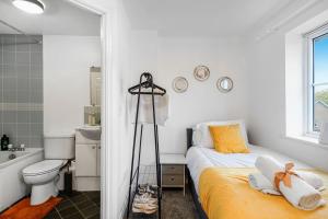 a bedroom with a bed and a bathroom with a tub at Shops 4min walk Family 2 En-suite Parking x1 in Langley Marish