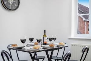 a table with glasses of wine and food on it at Shops 4min walk Family 2 En-suite Parking x1 in Langley Marish