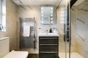 ein Badezimmer mit Waschbecken und Dusche in der Unterkunft Prv-Parking Jacuzzi Bath Families Groups in Elstree