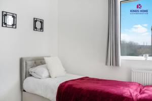 ein Schlafzimmer mit einem Bett mit einer roten Decke und einem Fenster in der Unterkunft 3BR 6 Beds Garden Parking x3 Kings Cross 25 mins & Harry Potter Studios in Borehamwood + 3 Fotos