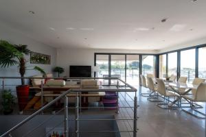 a room with chairs and a table and a television at SUPERBE VILLA VUE MER JUSQU'A 14 COUCHAGES La LONDE LES MAURES Entre HYERES et Le LAVANDOU 4 Etoiles PISCINE CHAUFFEE in La Londe-les-Maures