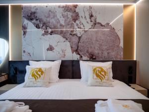 a hotel room with a bed with two pillows at Aslan Gold Hotel in Varna City