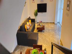a living room with a couch and a tv at Ventara Escape Bungalow by Palette Homes ? 4 BHK | Pvt Pool | Lonavala in Kārli
