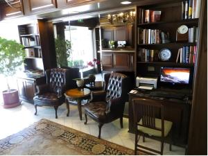 a living room with chairs and a table and a tv at Hilgard House Westwood Village in Los Angeles