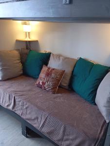 a couch with pillows on it in a living room at Petit studio lumineux vue montagne in La Mongie