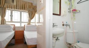a bathroom with a sink and a toilet and a sink at New Mong Kok Guest House in Hong Kong +242 photos