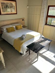 a bedroom with a bed with a table and a window at Mabel View in Cape Town