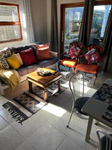 a living room with a couch and a table and chairs at Mabel View in Cape Town +28 photos