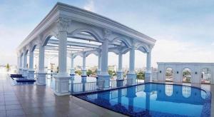 a large white building with a swimming pool at Adimulia Hotel Medan in Medan