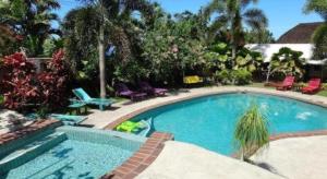 a swimming pool in a yard with chairs and tables at Le Manumea Hotel in Tiavi