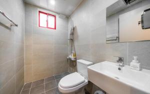 een badkamer met een toilet, een wastafel en een raam bij Tongyeong Daon Hotel in Tongyeong +25 foto's