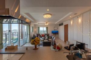 a kitchen and living room with a couch and a table at エンズプラザライカム1201 in Okinawa City