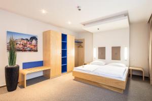 a bedroom with a bed and a bench in it at Hotel Global Inn in Wolfsburg +41 photos