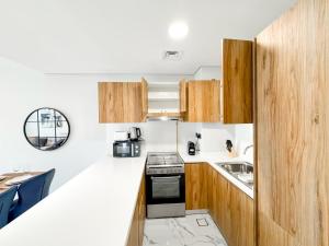 a small kitchen with a stove and a sink at Vista Grande Luxury 3br In Reem By Ayla in Abu Dhabi