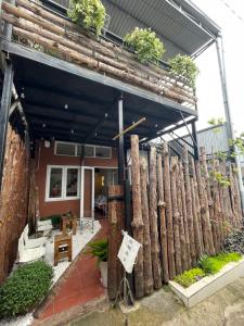 a house with a fence made out of logs at P&B Homestay - Đà Lạt in Da Thanh
