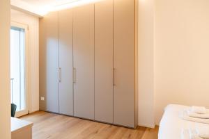 een slaapkamer met witte kasten en een bed bij Ca' Borsa IV - Suite con balcone in pieno centro in Treviso