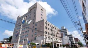 a tall white building on a city street at Albert Hotel in Dote-nagamachi