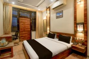 a bedroom with a large bed and a television at Townhouse Punnami Riverview Formerly Vihaan Square in Jaipur