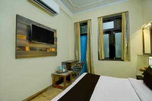 a hotel room with a bed and a tv at Hotel O Jaipuria Institute of Management Formerly Aishwarya Inn in Jaipur