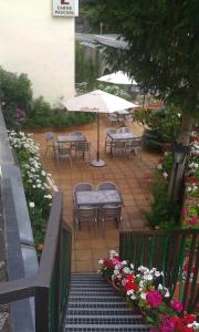a patio area with tables, chairs and umbrellas at Hostal Carme Pascual in Bohí