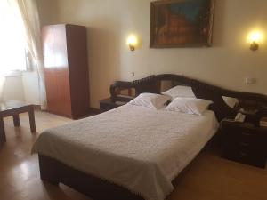 1 dormitorio con 1 cama grande con sábanas y almohadas blancas en Residencial Central, en Caldas da Rainha