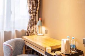 un bureau avec une lampe et deux chaises dans une pièce dans l'établissement Home Inn Nanjing Railway Station Xiaoshi Metro Station, à Nankin