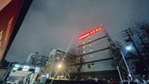 un bâtiment avec une enseigne sur le côté dans l'établissement Home Inn Nanjing Railway Station Xiaoshi Metro Station, à Nankin