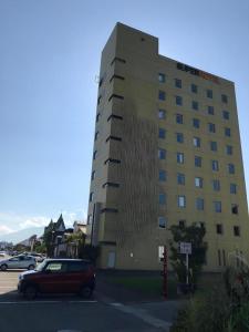 a building with a car parked in front of it at Super Hotel Arai-Niigata in Arai