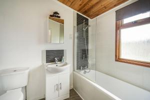 a bathroom with a sink and a tub and a toilet at Lakeview Lodge in Carnforth +20 photos