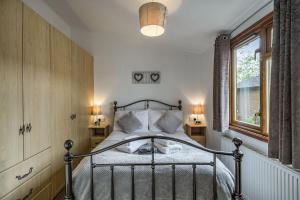 a bedroom with a bed and two lamps and a window at Lakeview Lodge in Carnforth