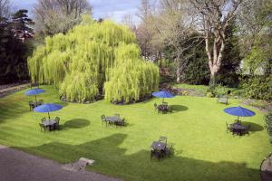 an aerial view of a park with tables and blue umbrellas at The Old Deanery in Ripon