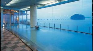 a large swimming pool with a view of the water at Hotel Takeshima in Gamagori