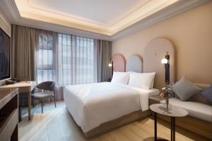a hotel room with a large bed and a desk at Mercure Xi'an History Museum in Xi'an